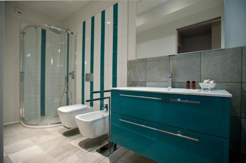 a bathroom with a blue cabinet and a toilet at Vinoteca La Sacrestia in Alba