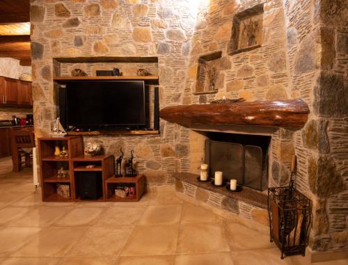 a stone wall with a tv and a fireplace at Villa Kore Elafonissi in Ãyios FÃ³tios