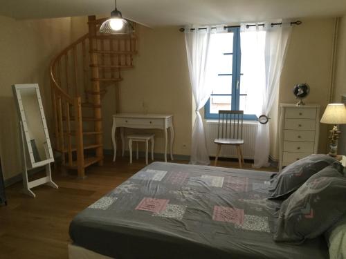 a bedroom with a bed and a staircase and a window at Tapis vert 2 in Cahors