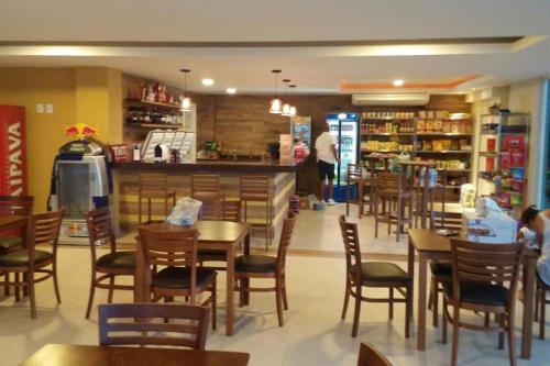 a restaurant with tables and chairs and a counter at APARTAMENTO EM ARRAIAL DO CABO - RJ in Arraial do Cabo