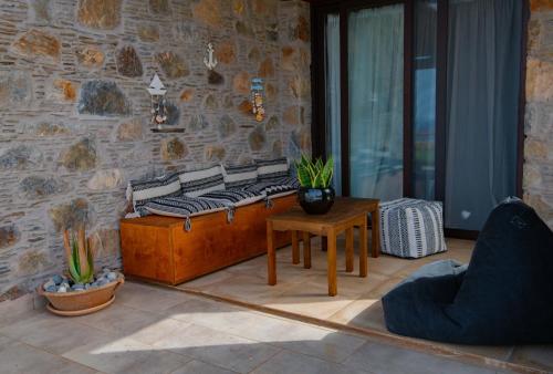 a room with a bench and a table and a stone wall at Villa Kore Elafonissi in Ãyios FÃ³tios