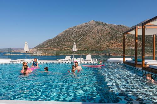 a group of people in a swimming pool with a mountain in the background at Blue Bay Lifestyle - ex Bali Blue Bay in Balíon