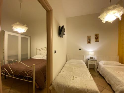 Un dormitorio con dos camas y un espejo. en B&B da Mimino e Franceschina, en Crispiano