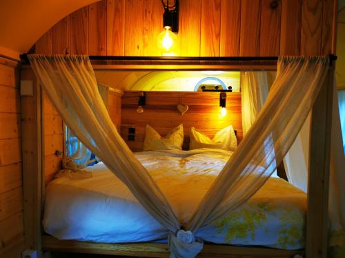 A bed or beds in a room at La Maison des Oiseaux. Roulotte