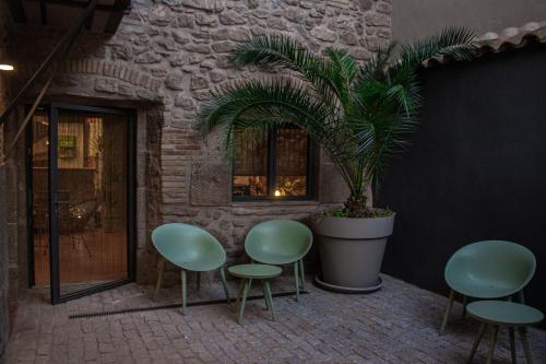 een groep groene stoelen en een potplant bij La Casa Del Miracle in Balaguer