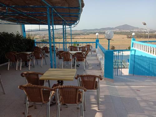 um pátio com mesas e cadeiras e uma piscina em Maliana Star em Tétouan