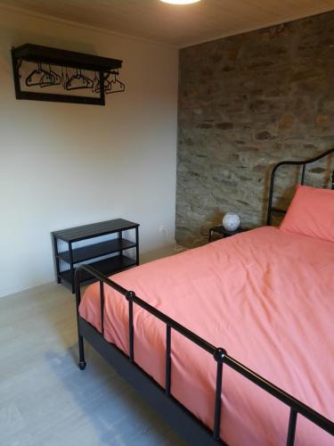 a bedroom with a bed and a stone wall at Al'fagne de boca in Bertogne