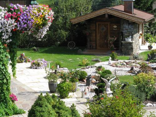 a garden with flowers and a small gazebo at Ferienpension Bierbaumer in Leogang
