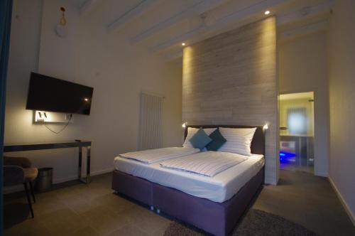a bedroom with a bed and a desk and a television at CityMotel Ziegenhain in Schwalmstadt