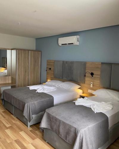 a bedroom with two beds and a air conditioner at Terzioglu Otel in Hopa