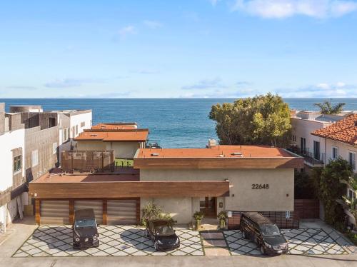 a house with cars parked in a parking lot at SA Carbon Beach Suites in Malibu