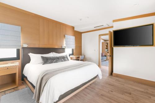 a bedroom with a bed and a flat screen tv at SA Carbon Beach Suites in Malibu