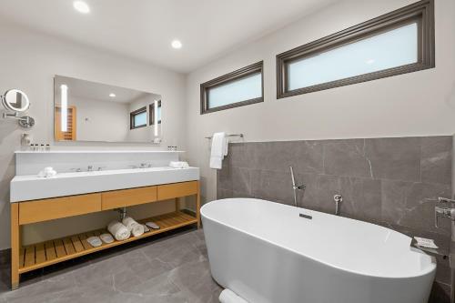 a bathroom with a large white tub and a sink at SA Carbon Beach Suites in Malibu