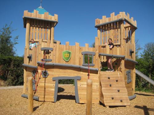 a wooden play structure with two people in it at Vakantiepark Koningshof in Rijnsburg