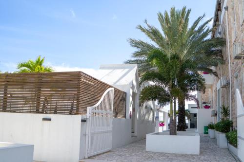 a large white building with palm trees at Saint Tropez Boutique Hotel in Willemstad
