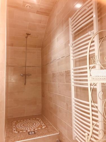 La salle de bains est pourvue d'une douche et d'un mur carrelé. dans l'établissement Fontaine Gargot - La sapinière 5p, à Poligny