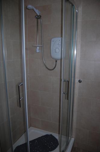 a shower in a bathroom with a glass shower stall at Creag Mhor Self Catering Holiday Apartment in Aberfoyle