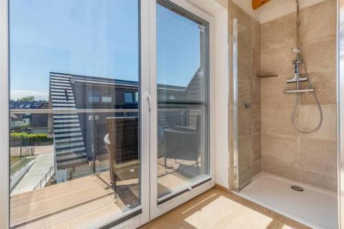 een badkamer met een douche en een groot raam bij Suite Windrose in Zingst