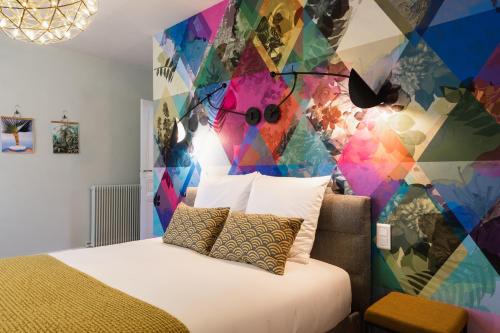 a bedroom with a bed and a colorful wall at Le Leon Bourgeois 6 pers Hypercentre Epernay in Épernay