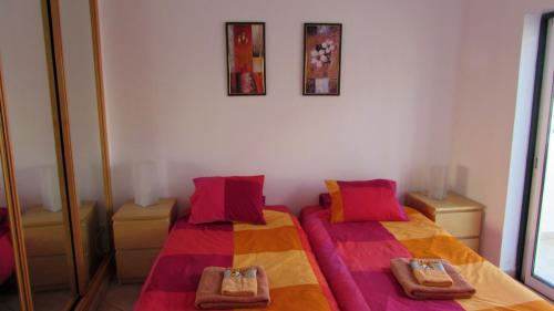 a bedroom with two beds with colorful sheets at Piscina Apartment in Santa Luzia