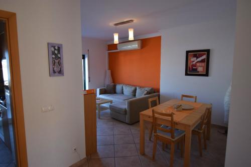 a living room with a table and a couch at Piscina Apartment in Santa Luzia