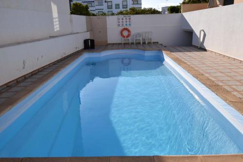 a large blue swimming pool on the side of a building at Piscina Apartment in Santa Luzia