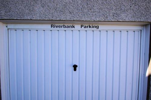 a white garage door with a sign on it at Riverbank in Callander