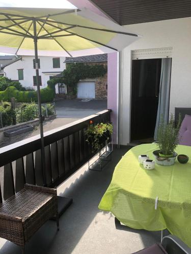 a balcony with a table and an umbrella at Haus Zissi in Burg-Reuland