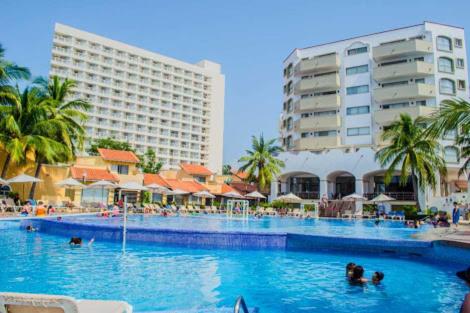 a large swimming pool with people in the water at VILLA PARA 8p 6A 2M dentro del HOTEL a un costado del Krystal IXTAPA cuenta con playa y WIFI in Ixtapa