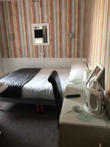 um quarto de hotel com uma cama e uma secretária com um computador em Kingscliff em Blackpool