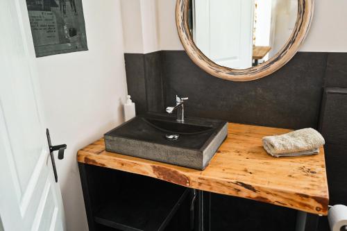 ein Bad mit einem schwarzen Waschbecken und einem Spiegel in der Unterkunft La Maison Des Artistes in Tourrette-Levens