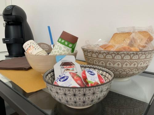 un bancone con tre ciotole di cibo e pane di Villa Giuseppina a Terracina