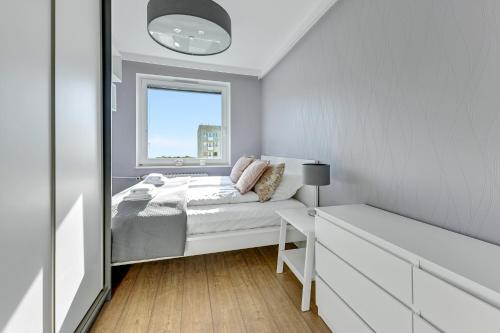 mała sypialnia z łóżkiem i oknem w obiekcie Comfort Apartments Wyspiańskiego w mieście Gdynia