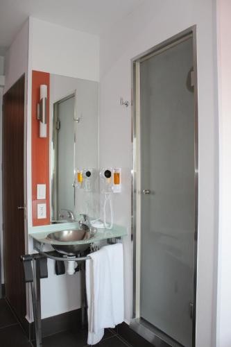 a bathroom with a sink and a shower at Hotel Hi! Fundidora in Monterrey