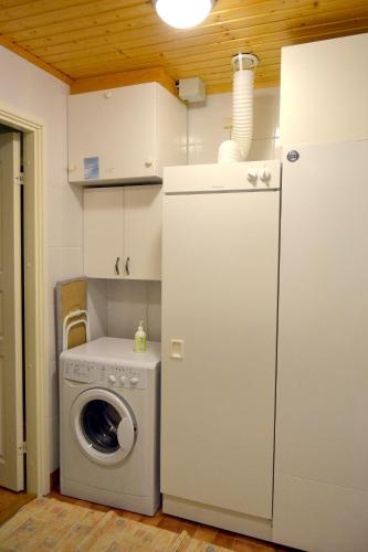 a kitchen with a washing machine and a refrigerator at Talo Ylläs in Äkäslompolo