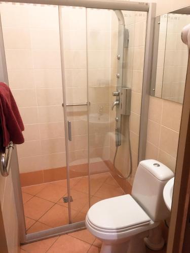 a shower stall in a bathroom with a toilet at Valensija in Jūrmala