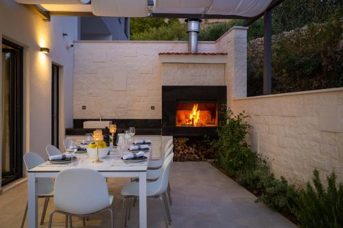 a table and chairs on a patio with a fireplace at Villa 9 in Podstrana