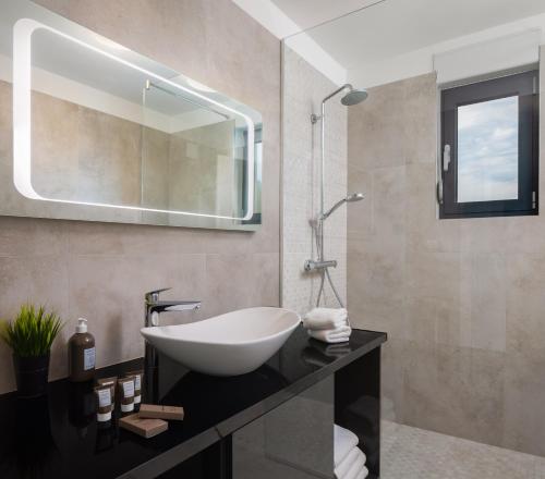 a bathroom with a white sink and a mirror at Villa 9 in Podstrana