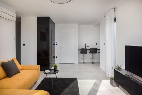 a living room with a couch and a tv at Villa 9 in Podstrana