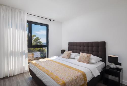 a bedroom with a large bed and a window at Villa 9 in Podstrana