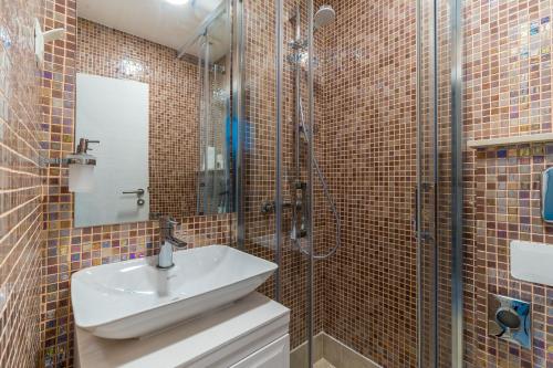 a bathroom with a sink and a glass shower at Art Hotel Dubrovnik in Dubrovnik