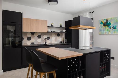 a kitchen with a black island with a wooden counter top at Villa 9 in Podstrana