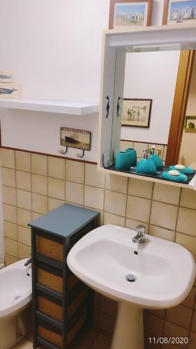 une salle de bain avec un lavabo et un miroir dans l'établissement Joli Appart 29m2 en Vieille Ville Menton 2 mins de la mer, à Menton