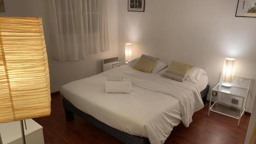 a bedroom with a large white bed with two pillows at 3 pièces Haut De Gamme Suquet Cannes in Cannes