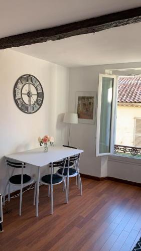 une salle à manger avec une table et une horloge au mur dans l'établissement 3 pièces Haut De Gamme Suquet Cannes, à Cannes