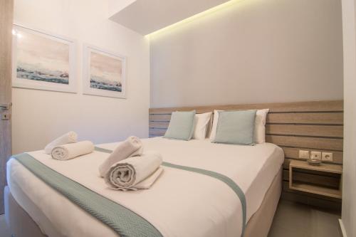 una camera da letto con un grande letto con asciugamani di AnDi's Apartment's Paleochora a Palaiochóra