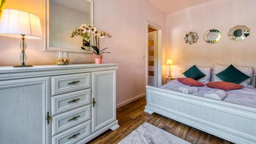 um quarto com uma cama com uma cómoda e um espelho em Apartament Centrum Holiday Mountain Residence - 5D Apartamenty em Świeradów-Zdrój