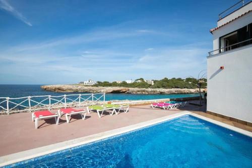 a swimming pool with a view of the ocean at Menurka - Cala Blanca in Cala Blanca