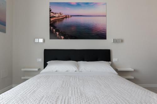 a bedroom with a large bed with a view of the water at PhotoRooms B&B in Siracusa
