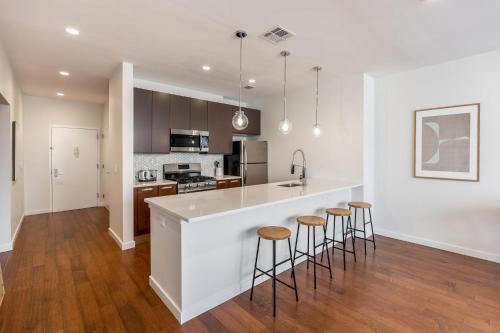 a kitchen with a white counter and bar stools at Kislak 302 Spacious 1BR in Heart of Downtown in Newark